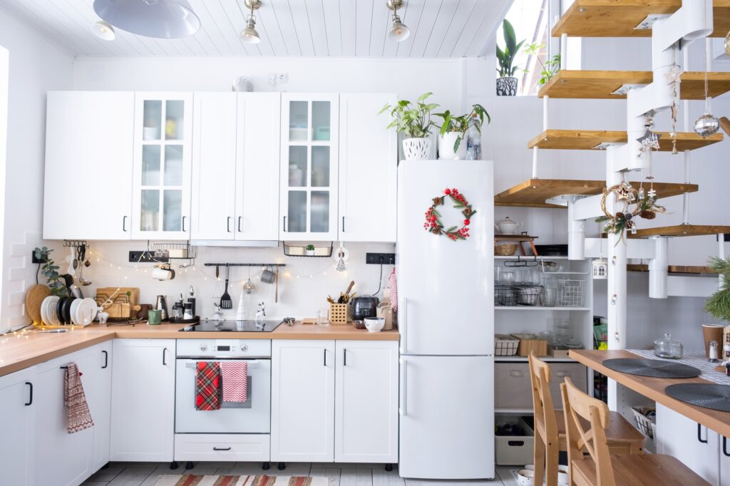 Festive Christmas decor in white kitchen, white modern loft interior with a metal modular ladder wit